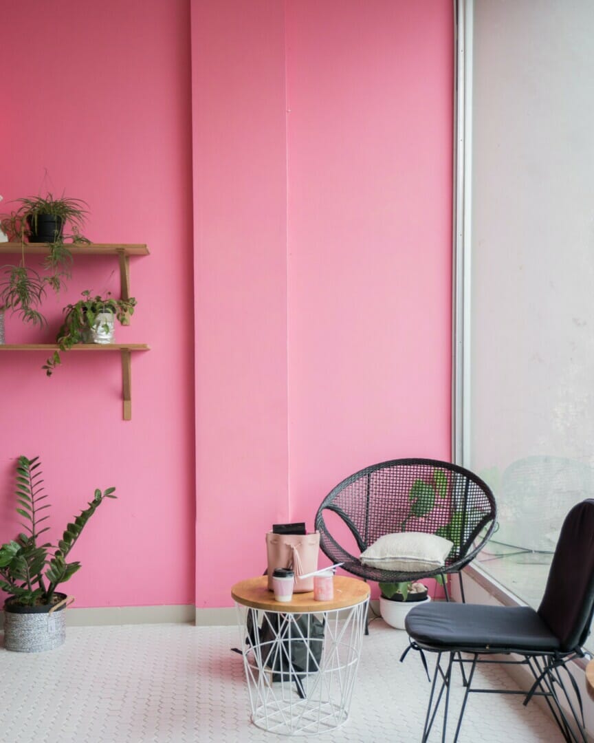 Clean office with a pink wall and office furniture